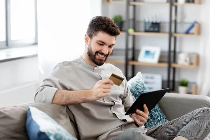 Smiling man paying off credit card balances with a Regional Finance debt consolidation loan