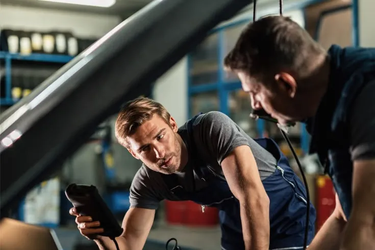 Mechanics diagnosing a car engine, a repair that can be covered by a Regional Finance emergency loan